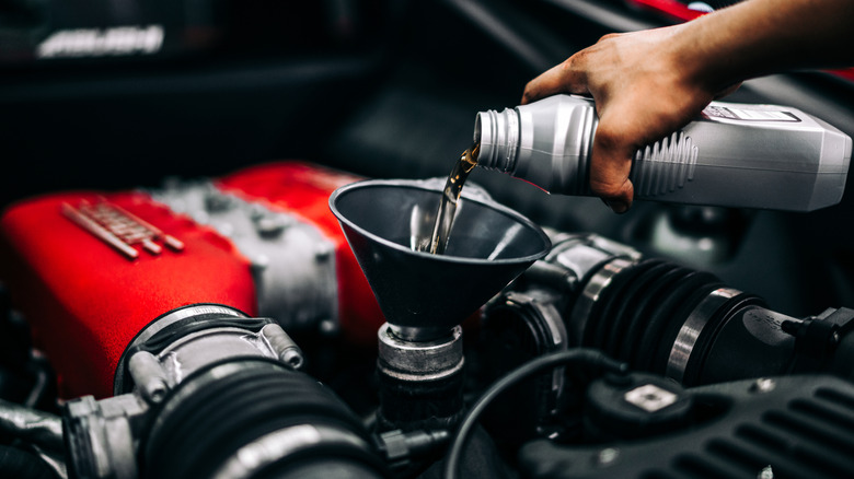 Pouring fresh oil into a high-performance Ferrari engine.