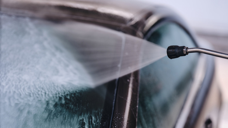A high pressure wash being used on a car's windshield