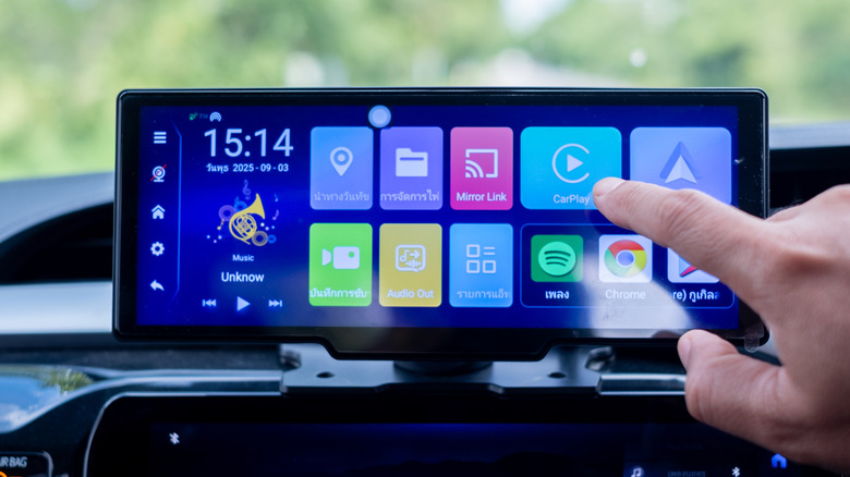 A motorist interacts with an infotainment system and its applications