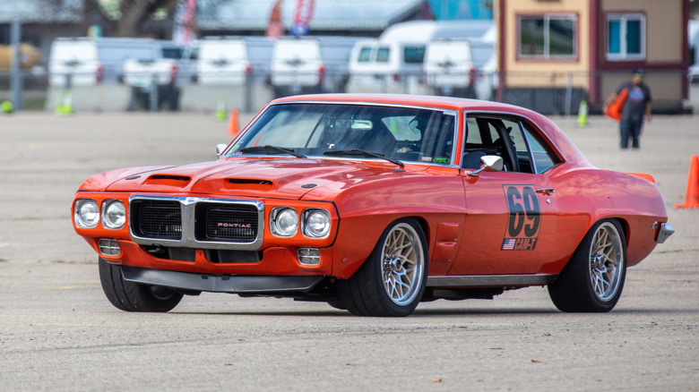 An orange 1970 Pontiac GTO restomod racing in autocross
