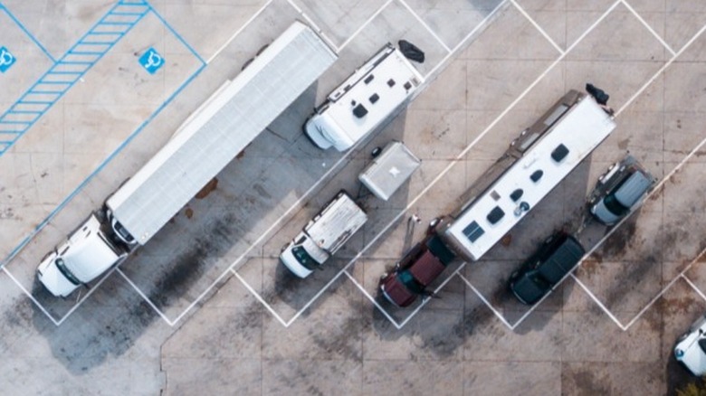 Aerial shot of a semi-truck, RVs, and other vehicles parked in a truck stop parking lot