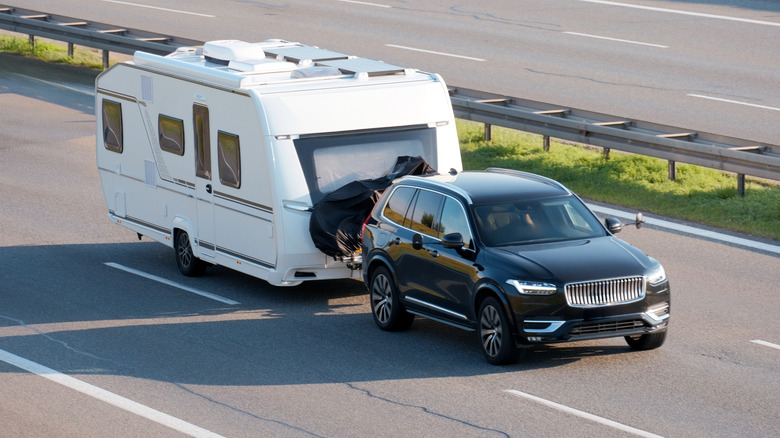 A Volvo SUV pulling an RV trailer home