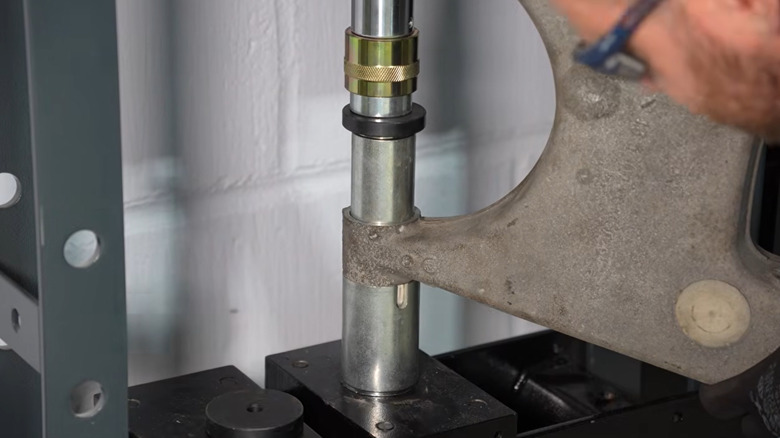 The threaded press/cup method being used to remove a suspension bushing.