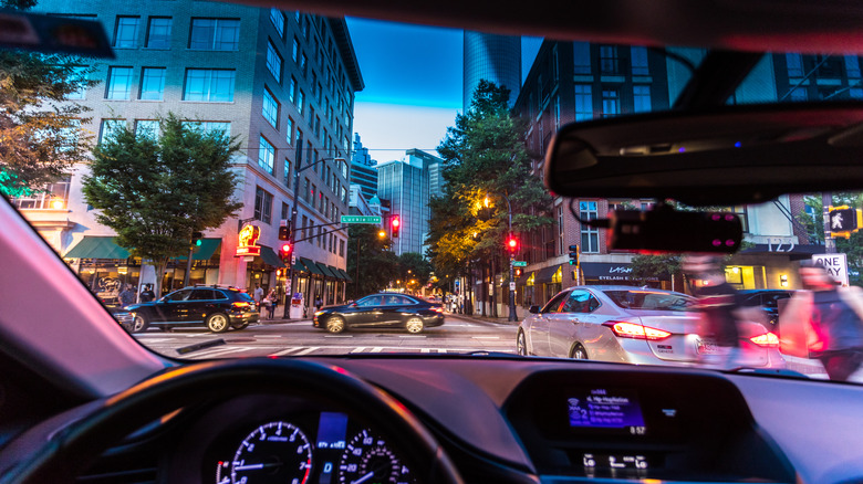 A busy city street seen from inside a car.