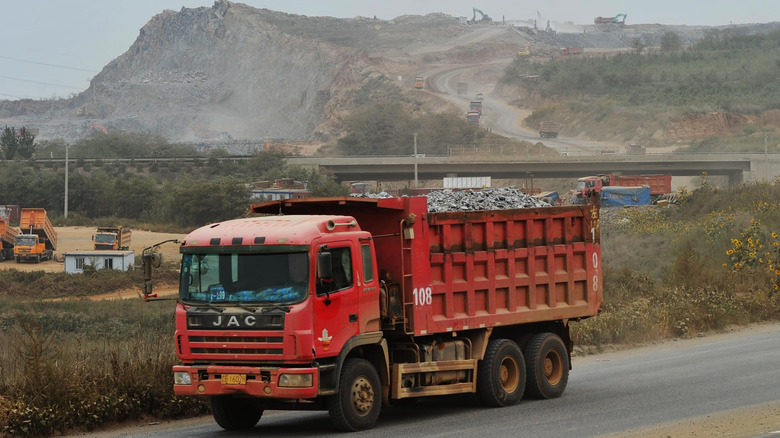 DALIAN, CHINA - SEPTEMBER 14: (CHINA OUT) A heavy truck carrying earth-rock runs at the construction site of Dalian's new airport on September 14, 2014 in Dalian, Liaoning province of China. Dalian started to build the world's largest seadrome by filling the sea with the construction fee of over ten billion RMB on Sunday. The construction of seadrome is going to be finished within the next 5 years. (Photo by VCG/VCG via Getty Images)