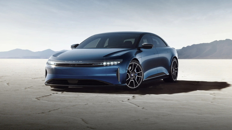 Front 3/4 view of a deep blue Lucid Air Sapphire electric sedan parked on an expansive salt flat.
