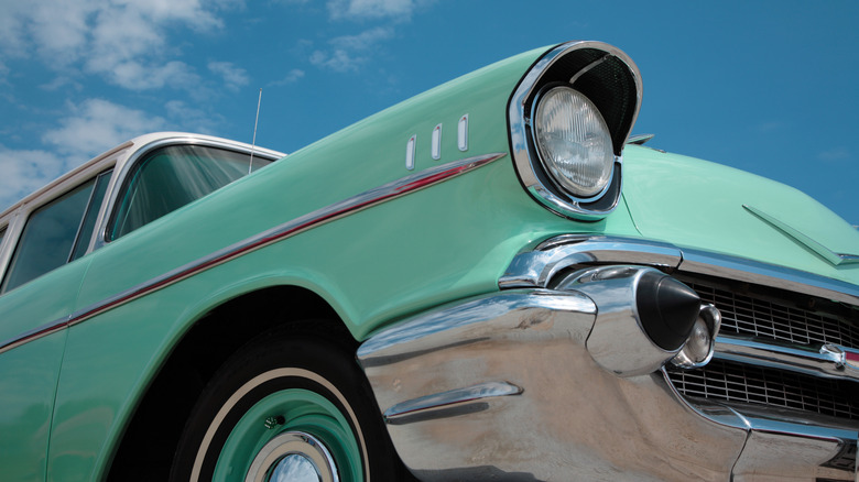 The front fender, headlight and grille of a Surf Green 1957 Chevrolet.
