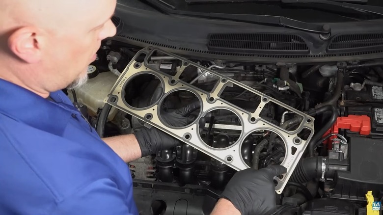 A mechanic holding a head gasket