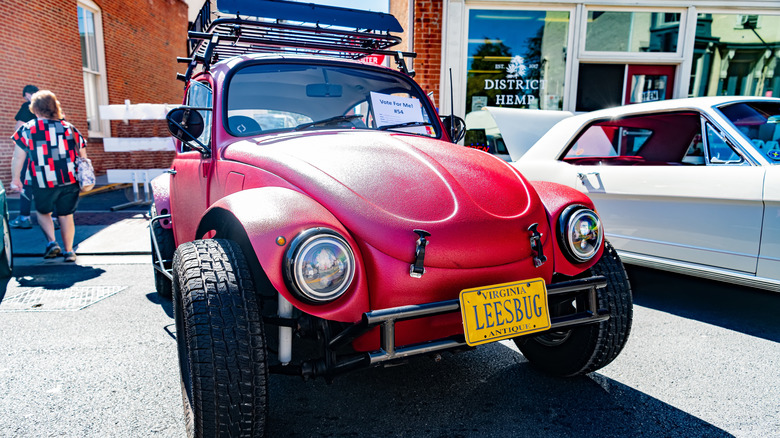 a red VW baja beetle with a Virginia license plate that reads LEESBUG