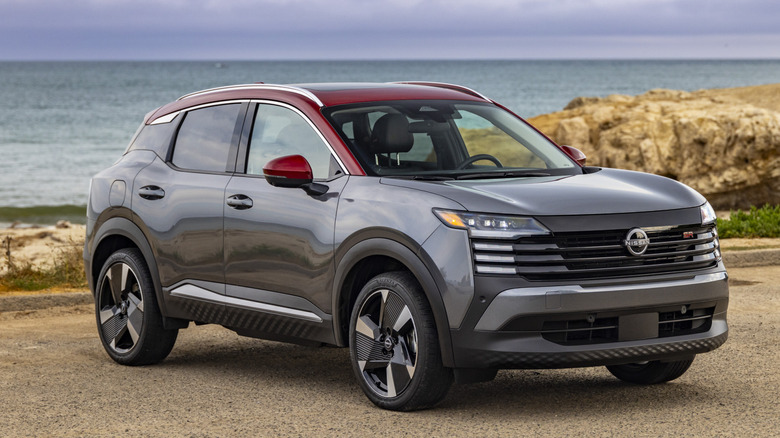 Gray 2026 Nissan Kicks SUV right front quarter view with dunes and ocean view in background