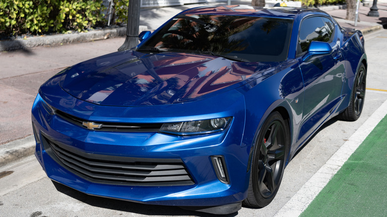 A blue Chevrolet Camaro is parked.
