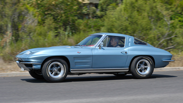 A light blue 1963 Chevy Corvette Sting Ray split window driving on the road