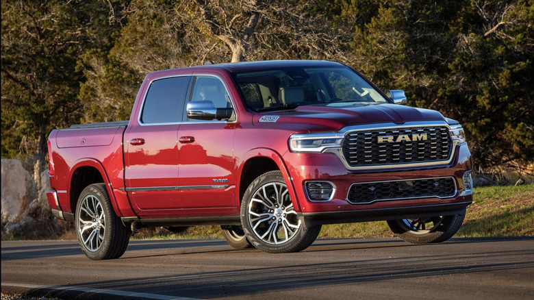 A ram 1500 in red parked at sunset in front of some trees