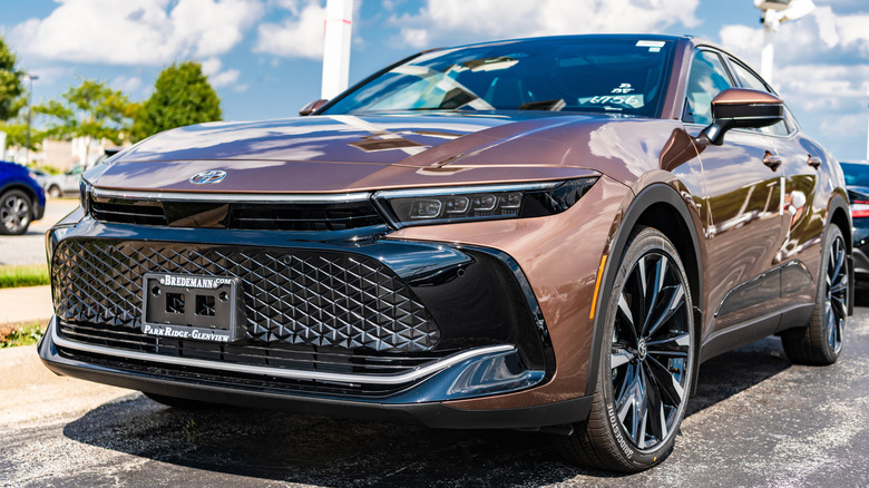 A bronze toyota crown parked in a dealer lot