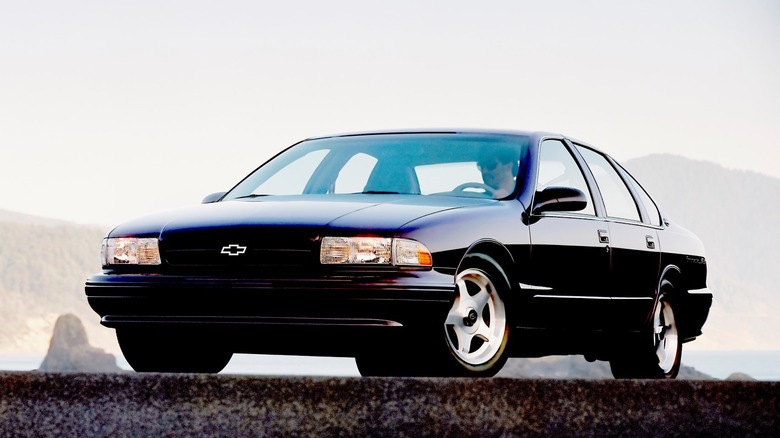 A black 1994 Chevrolet Impala SS with mountains in the background
