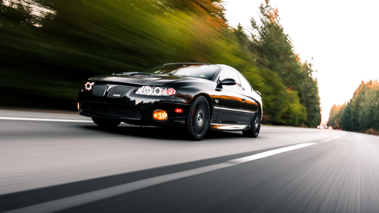 A Pontiac GTO driving connected nan road pinch trees connected nan broadside of nan road