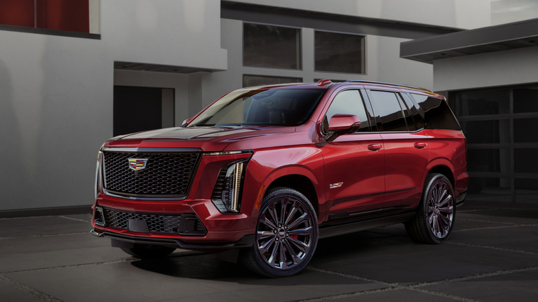 A red 2025 Cadillac Escalade-V parked near a house