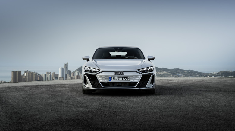 An Audi S e-tron GT sitting parked near a city.