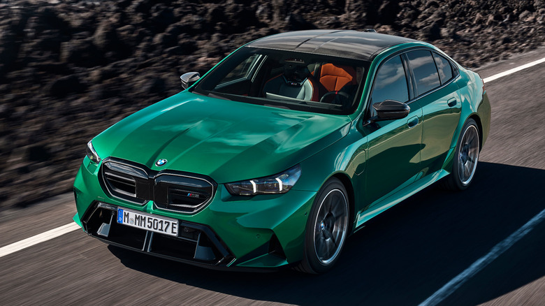 A green BW M5 driving down a road