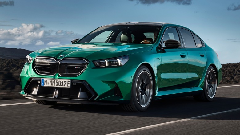 BMW M5 driving at speed on a volcanic road.