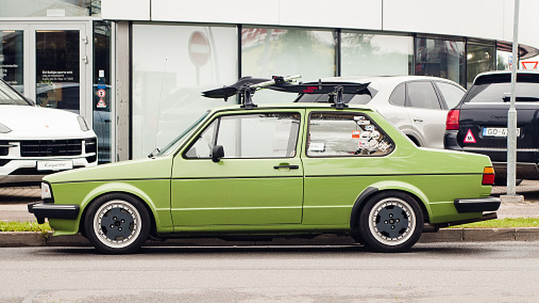 A green Volkswagen Jetta with a bike rack on the roof