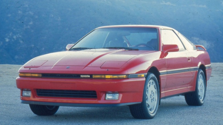 A 1987 Toyota Supra Turbo in red parked outside.