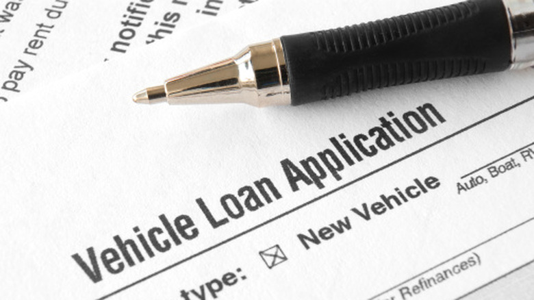 A pen next to a vehicle loan application.