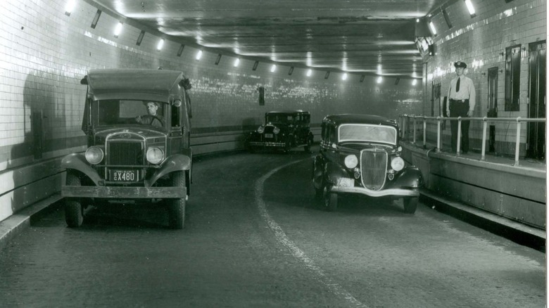 A policeman stands on the catwalk adjacent to traffic in the Holland Tunnel.
