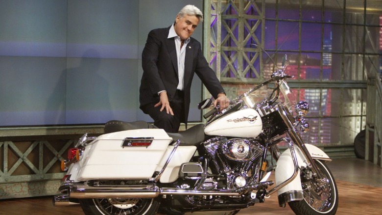 Jay Leno standing beside a Harley-Davidson motorcycle on "The Tonight Show with Jay Leno"
