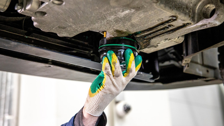 Technician removing the old oil filter from a car engine