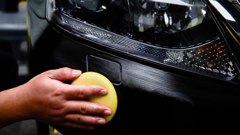 Person applying car wax with a sponge