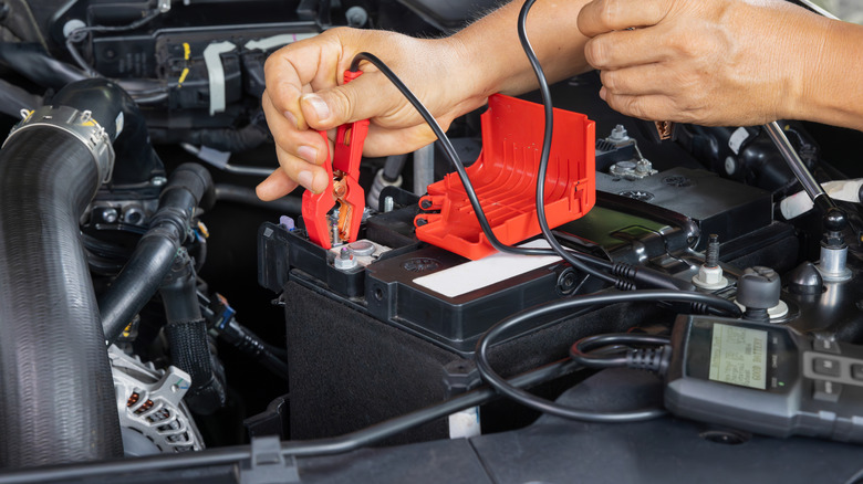 A car battery being checked with a digital tester.