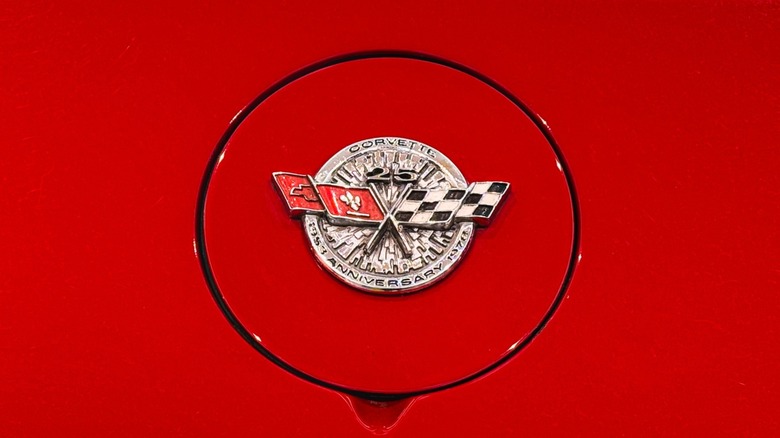Close up of a Corvette brand badge on a red car.