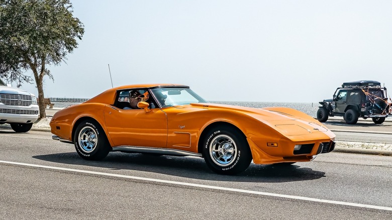 Photo of an orange 1977 Corvette at a car show.