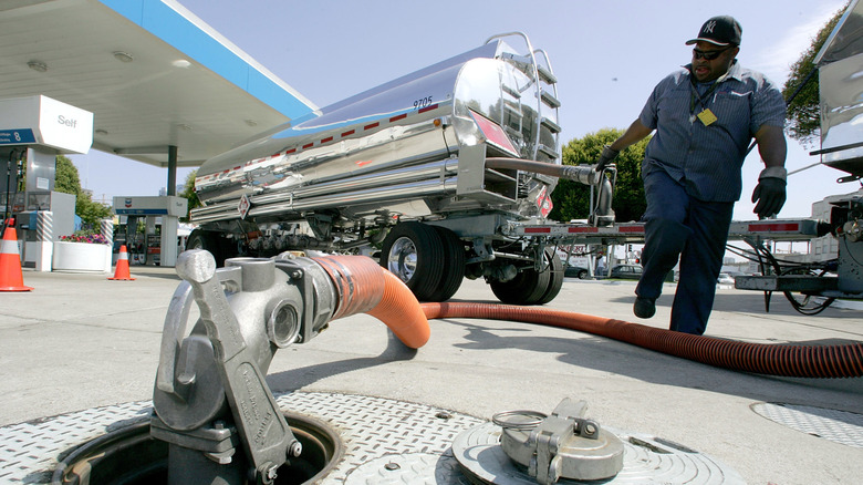 Tanker truck driver Bill Moore pumps gasoline into a ground tank at a Chevron service station during a delivery August 16, 2005 in San Francisco, California.