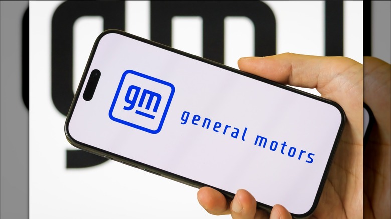 A smartphone displaying the General Motors logo.