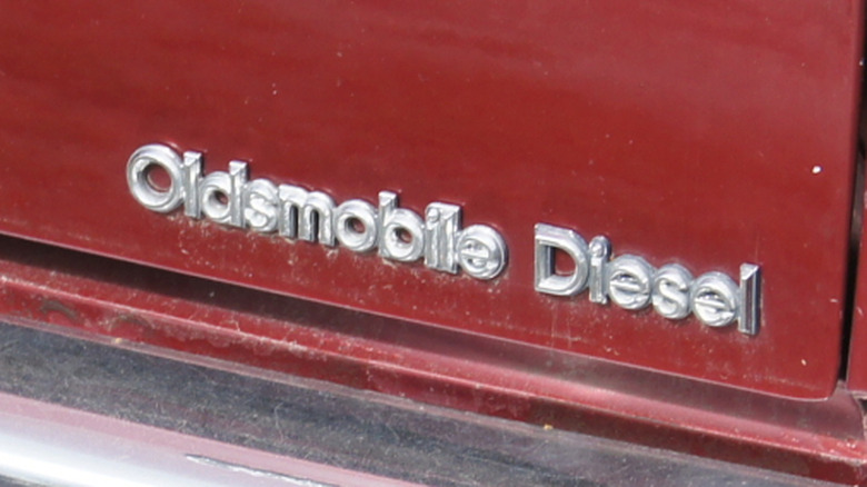 A closeup of the Oldsmobile Diesel badge on a red 1982 Diesel 350 V8-powered Oldsmobile Cutlass Cruiser