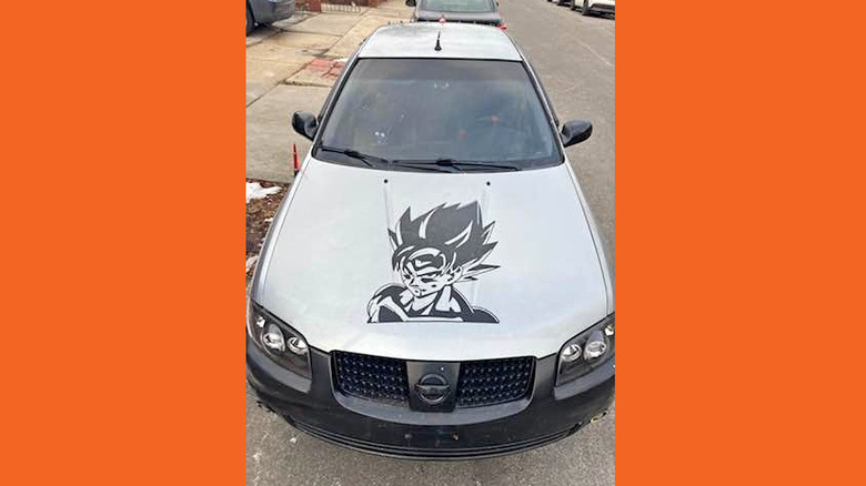 A Nissan Sentra with a replaced front bumper and Goku on the hood