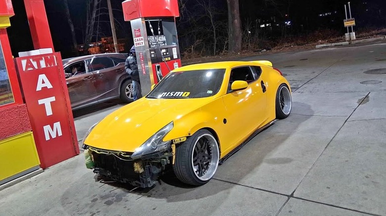 A yellow Nissan 370z coupe with no front bumper at a gas station