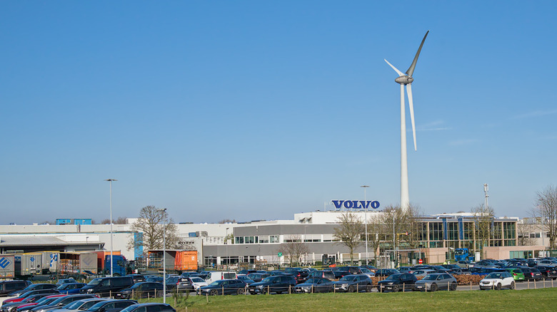 OOSTAKKER, BELGIUM, MARCH 4, 2026, Volvo factory with car parking in front and wind turbine in Oostakker, Ghent, Flanders, Belgium