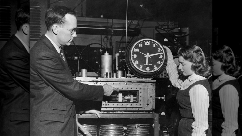 Dr. Charles H. Townes, Columbia University professor who invented the "Maser," shows Marianne MacDonald how the atomic clock differs from common electric clock.