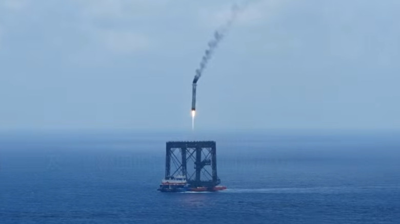 The first-stage booster of the CALT Long March 10B rocket comes in for capture in a ship-mounted net structure