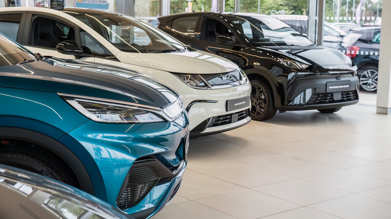 A row of BYD cars are displayed inside a car showroom.
