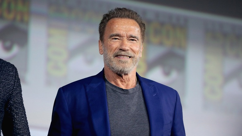 Arnold Schwarzenegger in a blue suit jacket at a Comic-Con