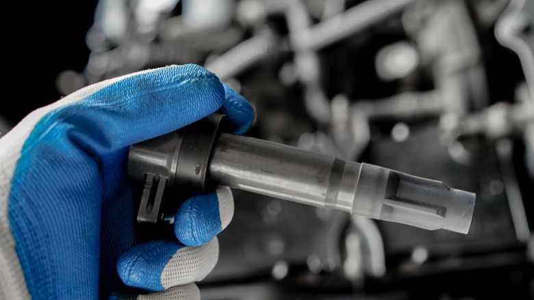 Gloved hand holding coil pack