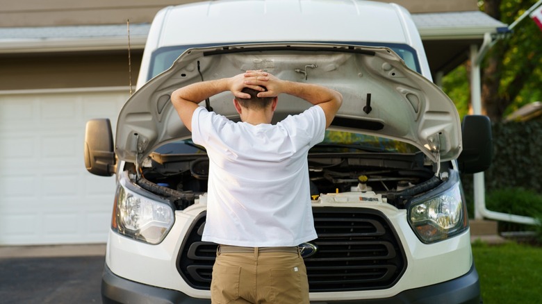 Man standing in front of van with hood up