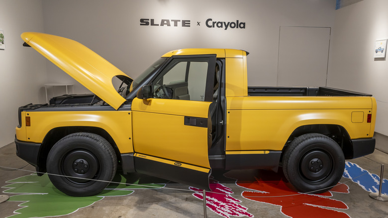 A yellow Slate Truck on display with its hood and doors open.