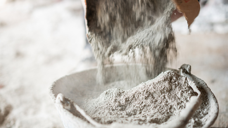 Pouring concrete powder mix into a bucket for construction