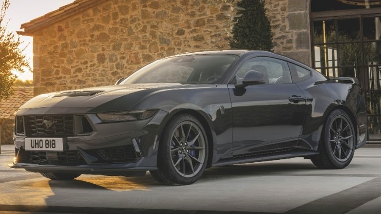 A black Ford Mustang Dark Horse sitting in front of a stone building