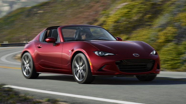A red 2024 Mazda MX-5 RF driving along a curve
